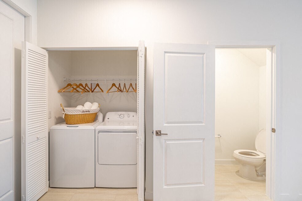 a laundry room with a washer and dryer and a toilet