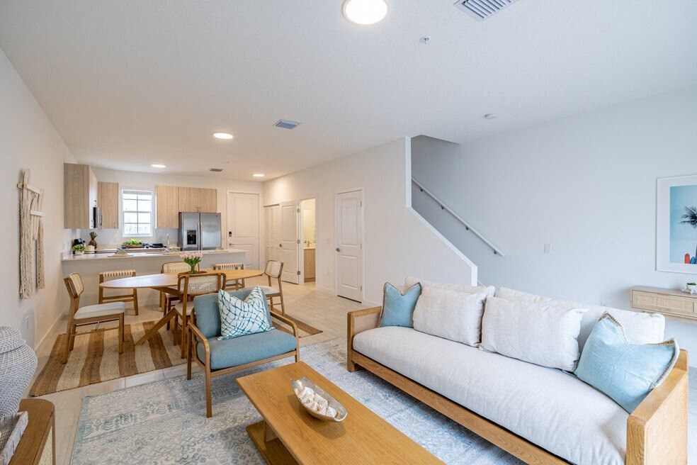 a living room and kitchen with a couch and a table
