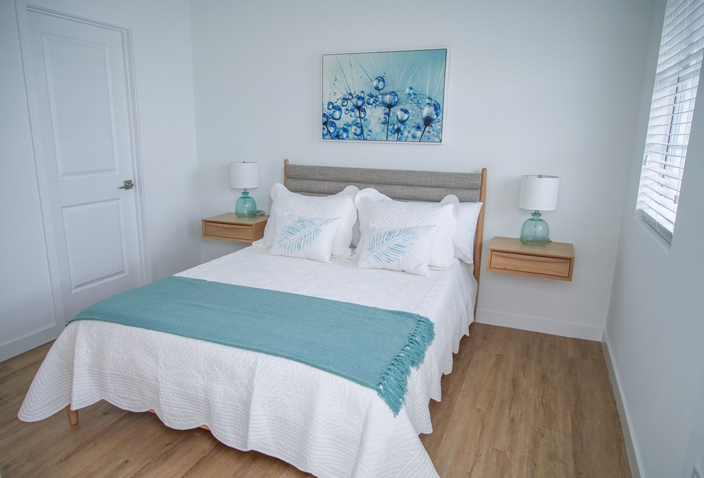 a bedroom with a bed and a painting on the wall