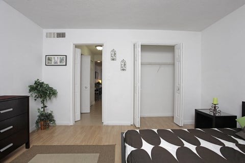 a living room with a couch and a hallway to a bedroom and a closet