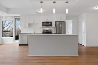 a white kitchen with a large island in the middle of it