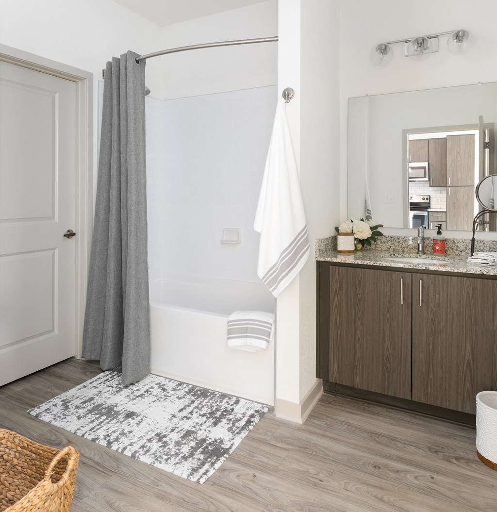a bathroom with a shower and a sink and a rug