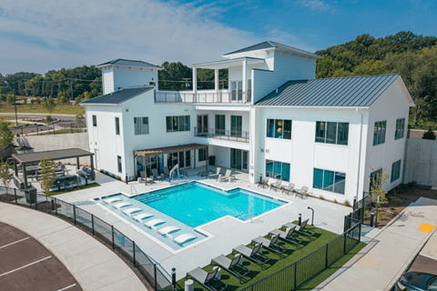 A large white house with a pool in the backyard.