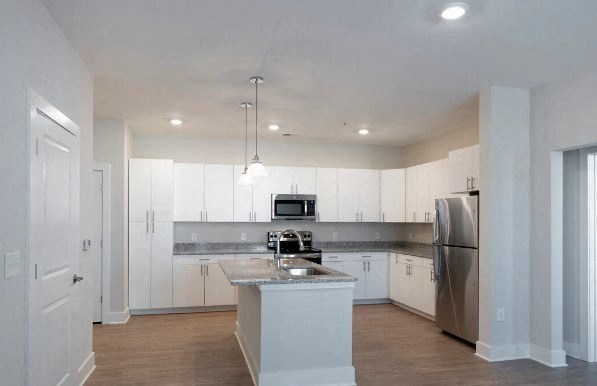 a kitchen with white cabinets and a stainless steel refrigerator