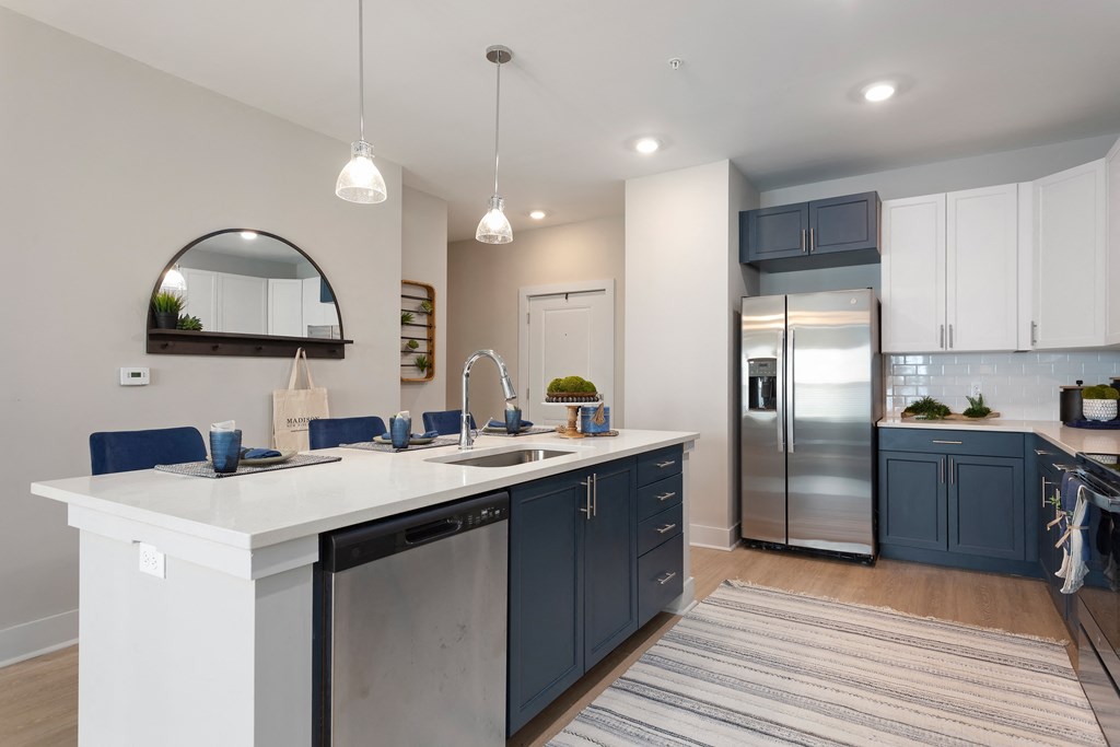 a large kitchen with blue cabinets and a white counter top