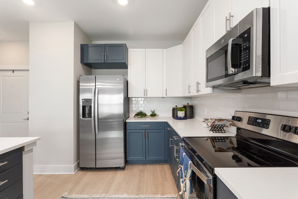 an open kitchen with stainless steel appliances and white cabinets