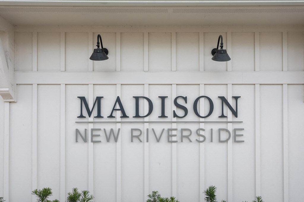 the sign new riverside on the side of a white building