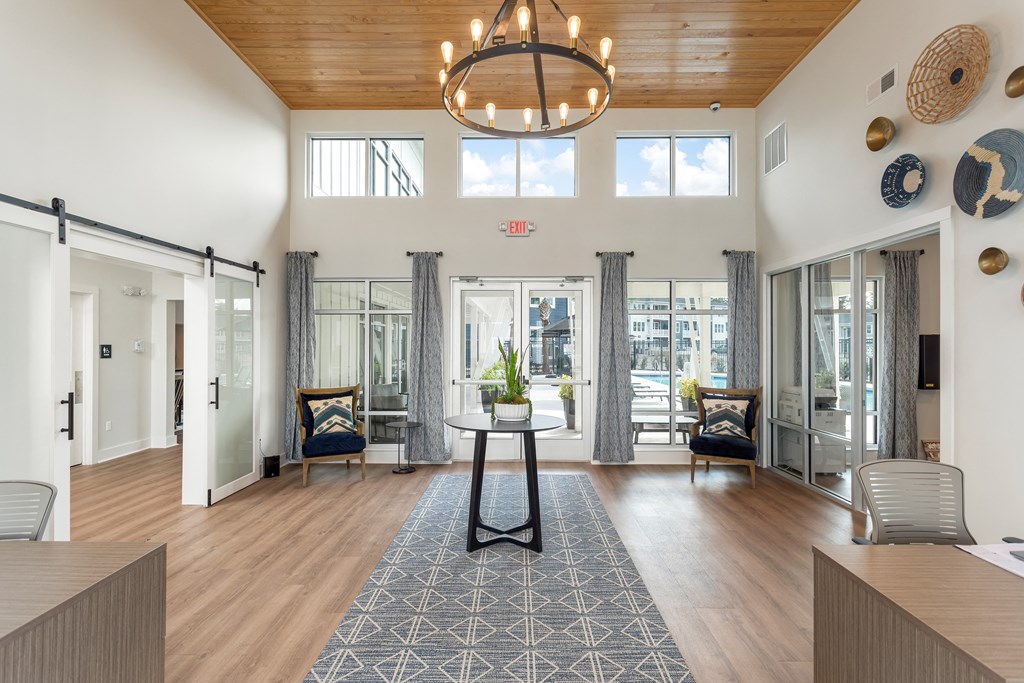 a living room with a round table in the center and sliding glass doors