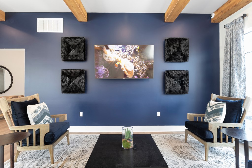 a living room with blue walls and a tv on the wall