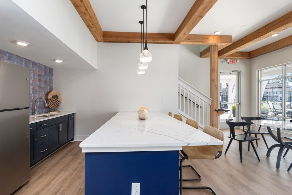 a large kitchen with a blue island and white quartz counter top