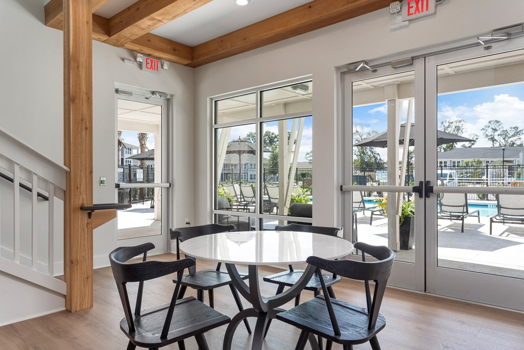 a dining area with a table and chairs and doors to a patio