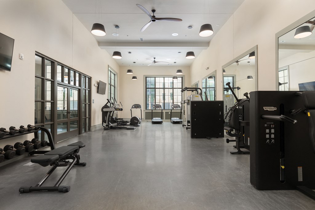a workout room with weights and cardio equipment in a building