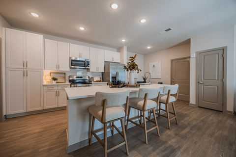 A kitchen with a table and chairs.