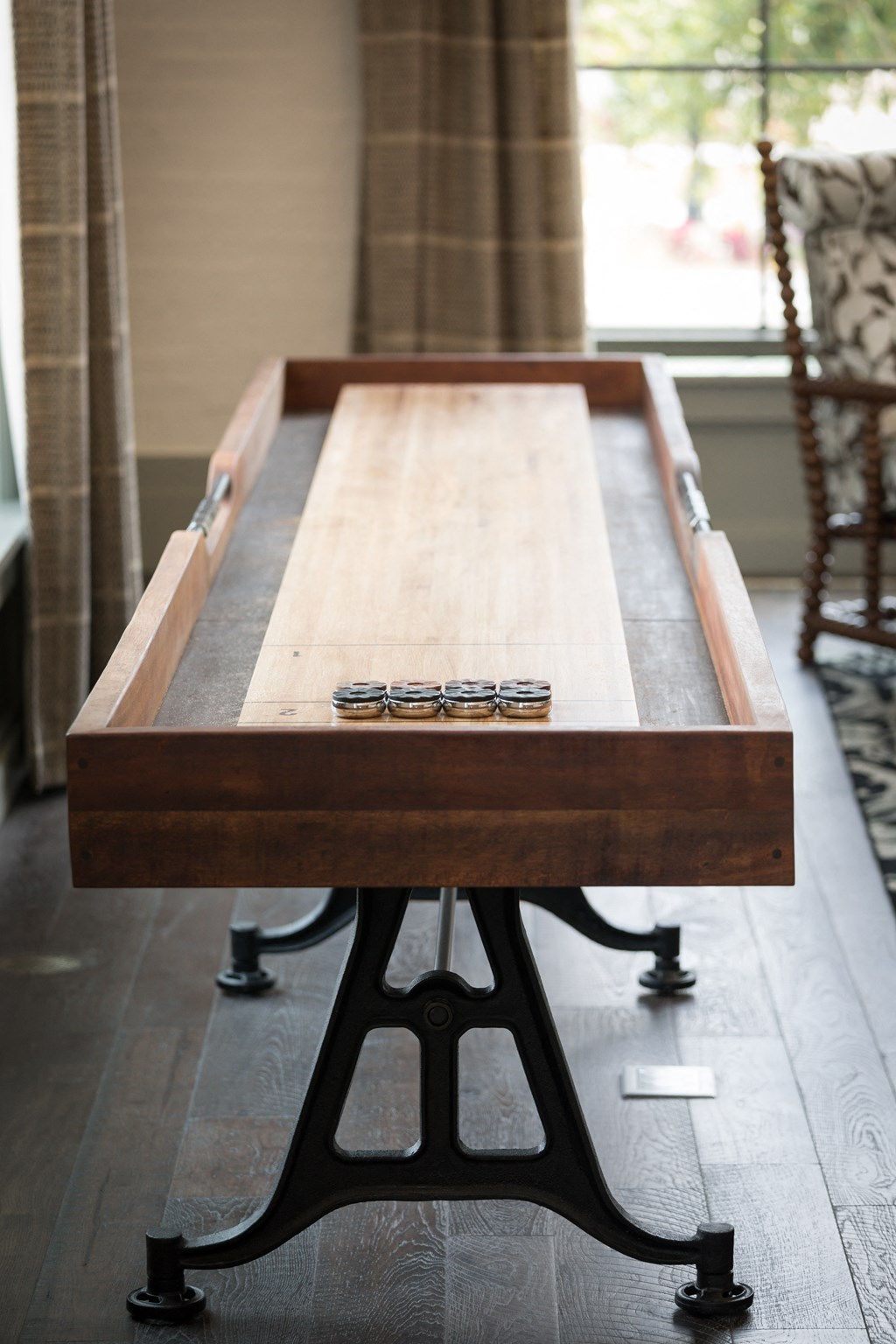 a wood and metal shuffleboard table in a living room