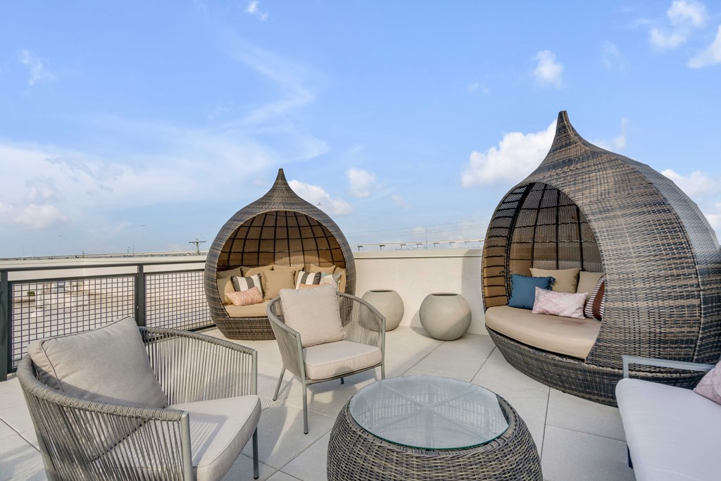 a rooftop terrace with two couches and chairs and a table