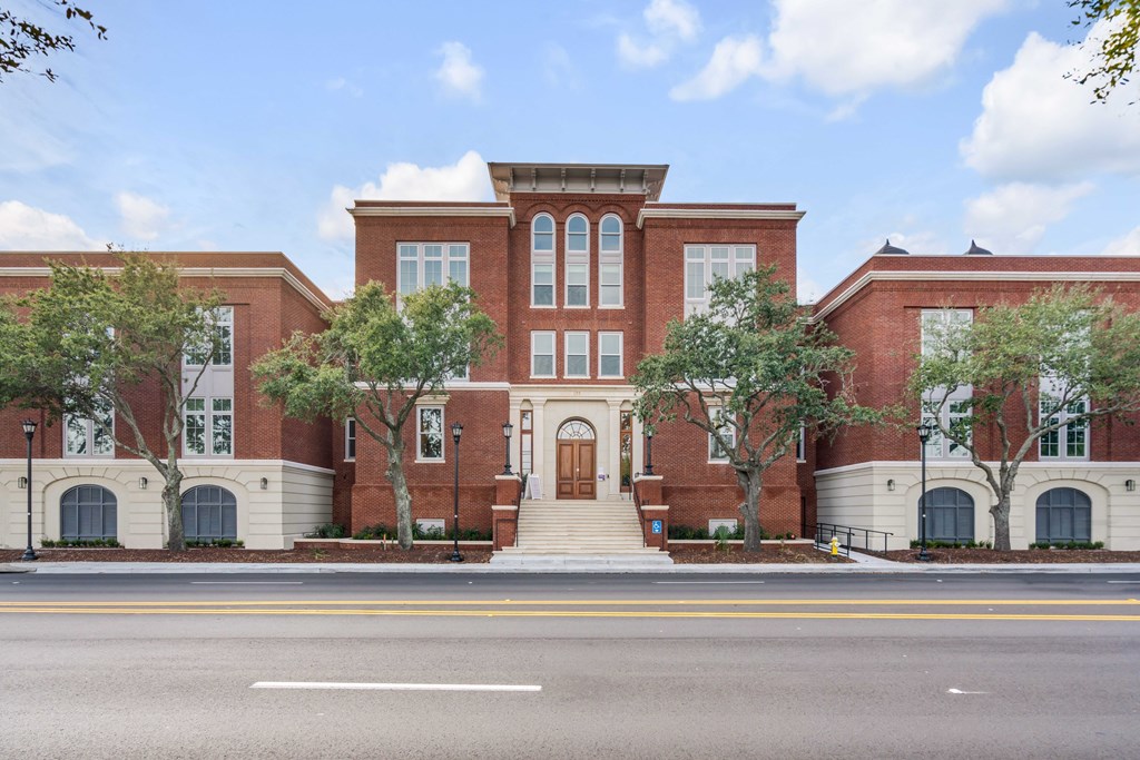a large red brick building with a street in front of it