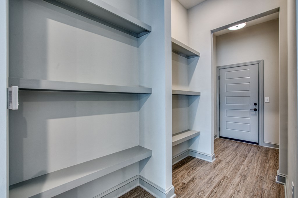 an empty walk in closet with shelves and a door