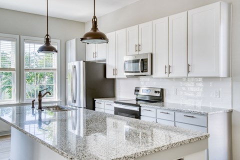 a kitchen with white cabinets and a granite counter top