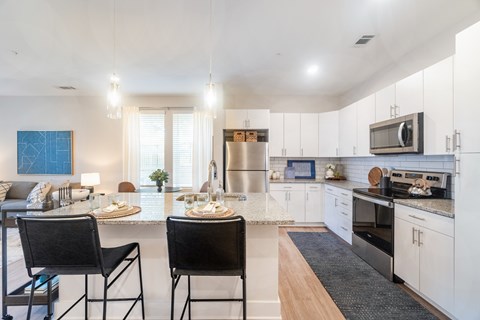 A kitchen with a table and chairs in front of a window.