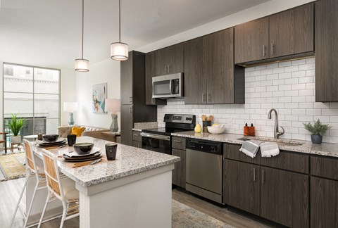 an open kitchen and dining area with a marble counter top