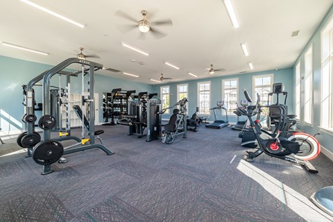 A spacious gym with a variety of equipment including treadmills, weights, and exercise bikes.