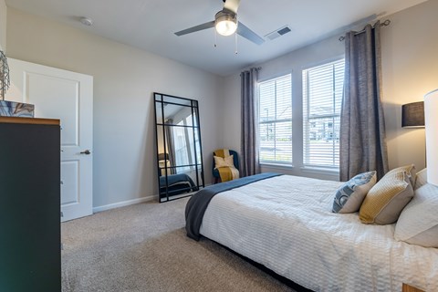 A bedroom with a large bed and a ceiling fan.