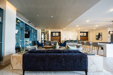 A modern living room with a dark blue sofa and a marble coffee table.