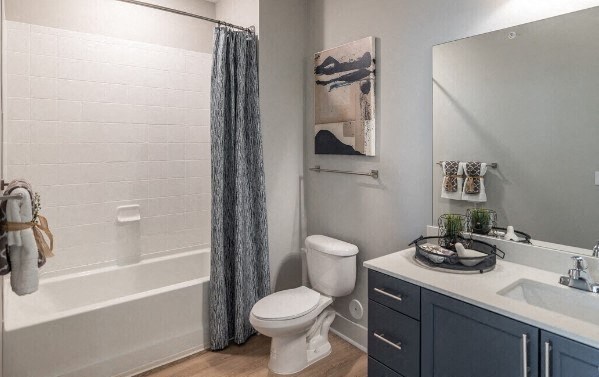 a bathroom with a toilet and a shower and a sink