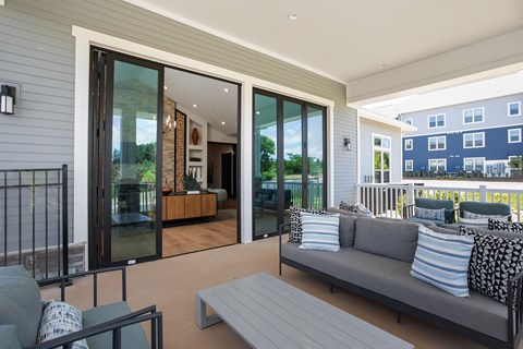 A modern outdoor living space with a grey sofa and a coffee table.