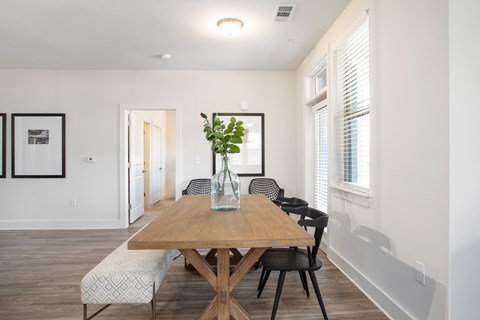 A dining room with a wooden table and chairs.
