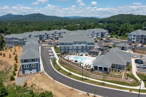 A large resort with a swimming pool and a mountain in the background.