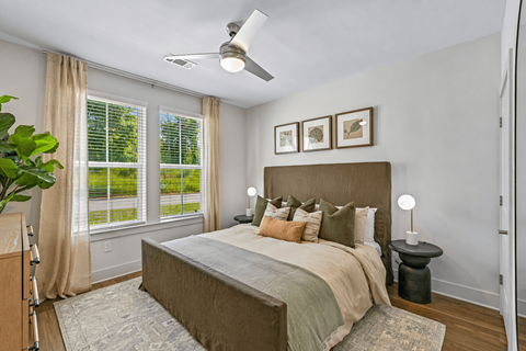 A bedroom with a large bed and a ceiling fan.