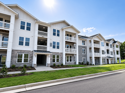 A row of modern apartment buildings with balconies and multiple windows.