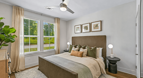 A bedroom with a large bed and a ceiling fan.