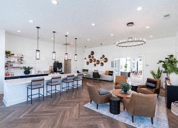 a living room with a kitchen and a table and chairs