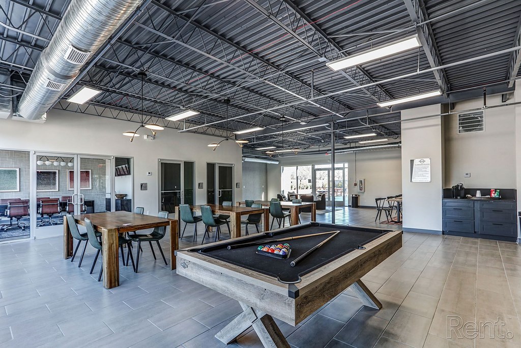 a game room with a pool table and tables