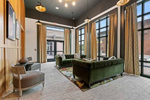 a living room with couches and chairs and large windows