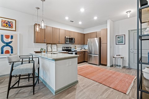 a kitchen with a large island and a stainless steel refrigerator