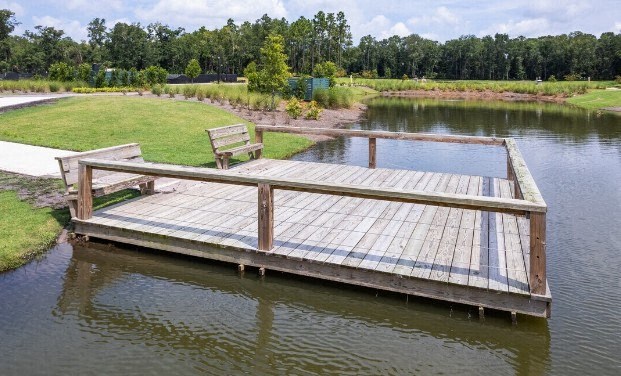 a wooden dock with a bench on the water