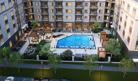 A large swimming pool surrounded by a grassy area and trees.