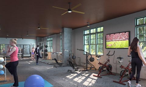 A gym with people exercising and a television screen showing a football game.