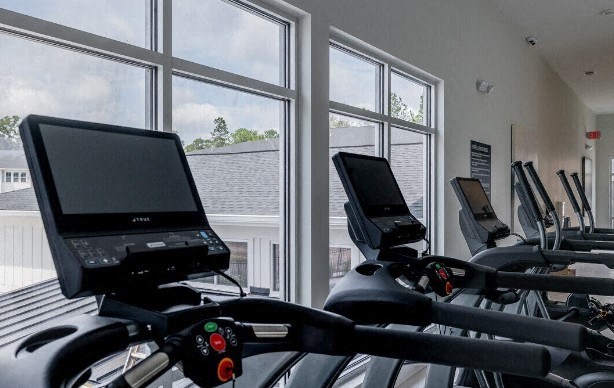 a gym with a bunch of exercise bikes and windows