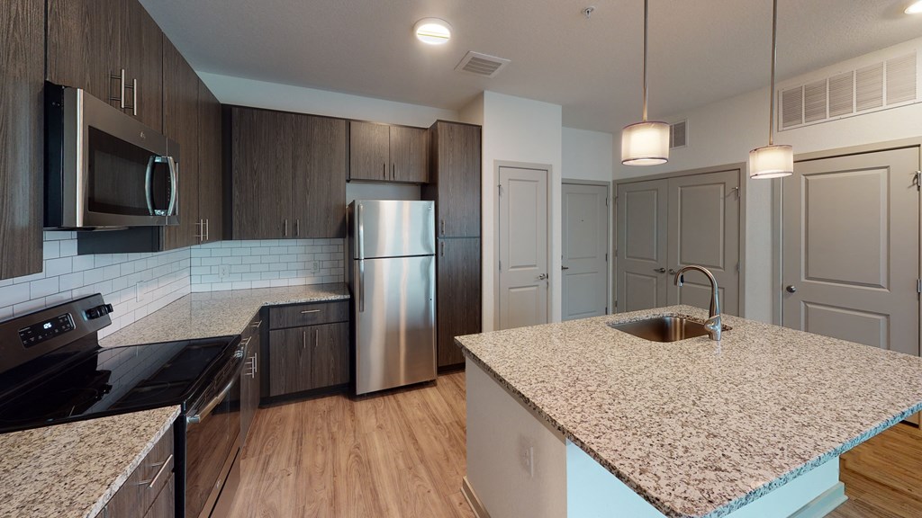 an updated kitchen with granite counter tops and stainless steel appliances