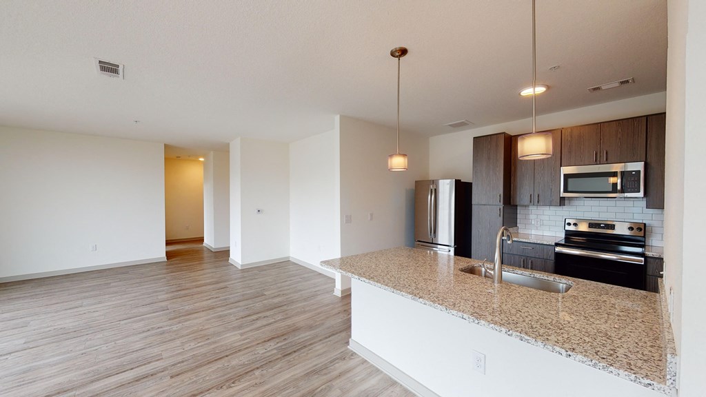 an empty kitchen with a granite counter top and