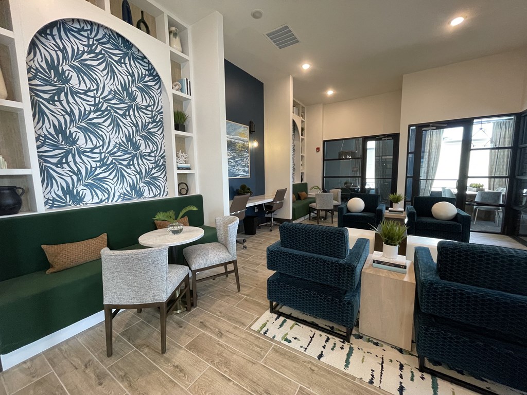 a living room with chairs and tables and a large window