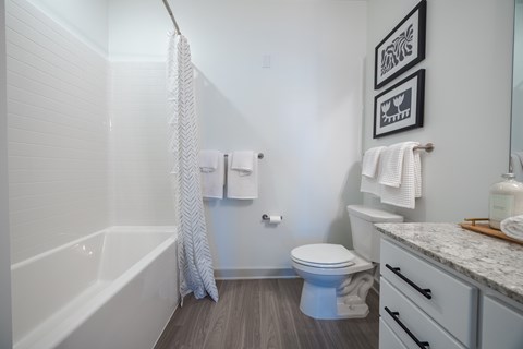 A white bathroom with a toilet, sink, and bathtub.