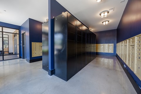 A long hallway with a series of lockers on the right and a door on the left.