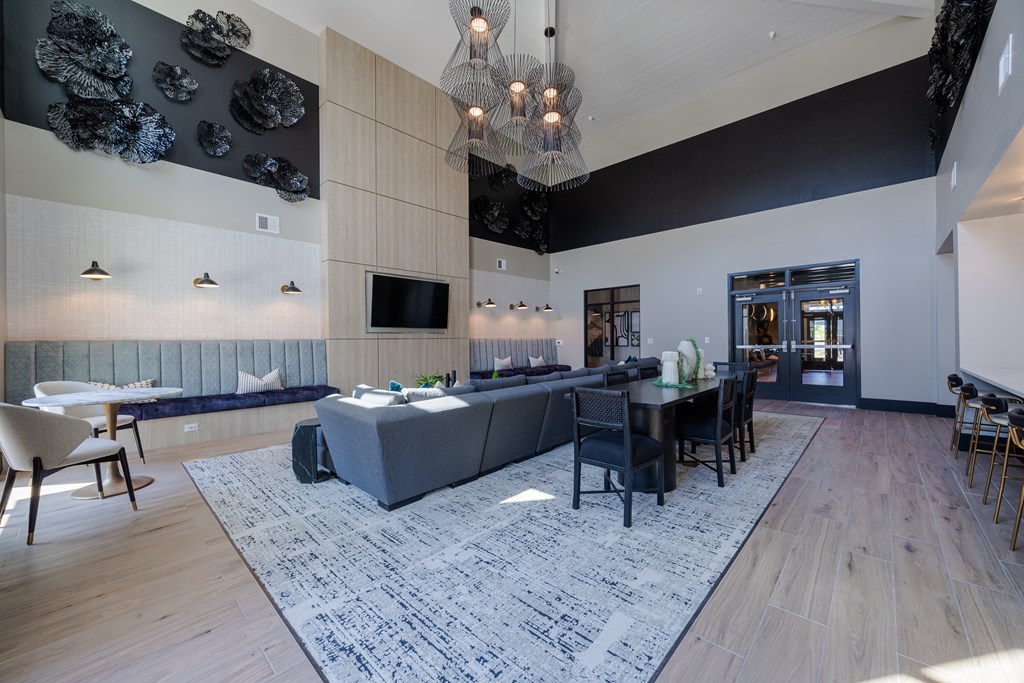 A modern living room with a grey sofa and a wooden floor.