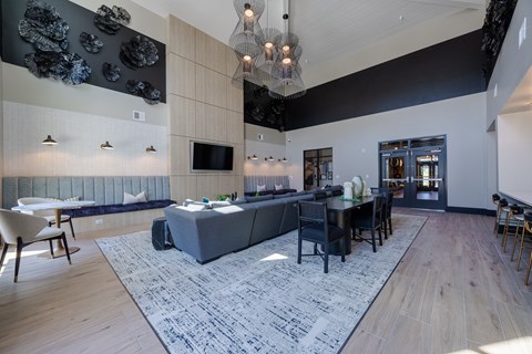 A modern living room with a grey sofa and a wooden floor.