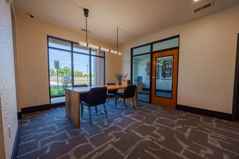 A conference room with a table and chairs and a view of the outside.